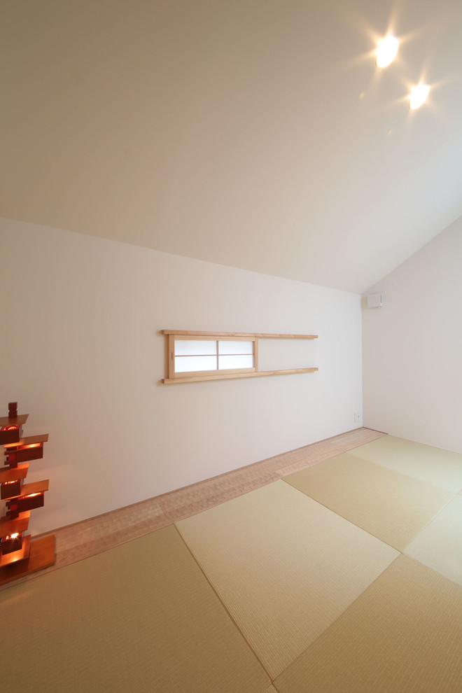 Modelo de sala de estar cerrada de estilo zen pequeña sin televisor con paredes blancas, tatami y suelo verde