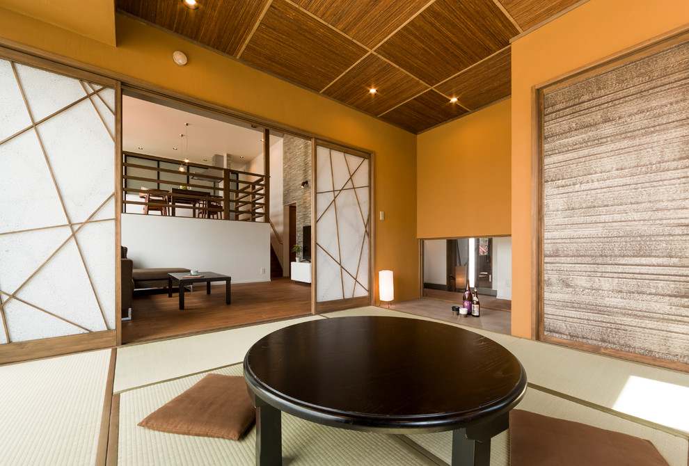 Aménagement d'une salle de séjour craftsman avec un mur beige, un sol de tatami et un sol vert.