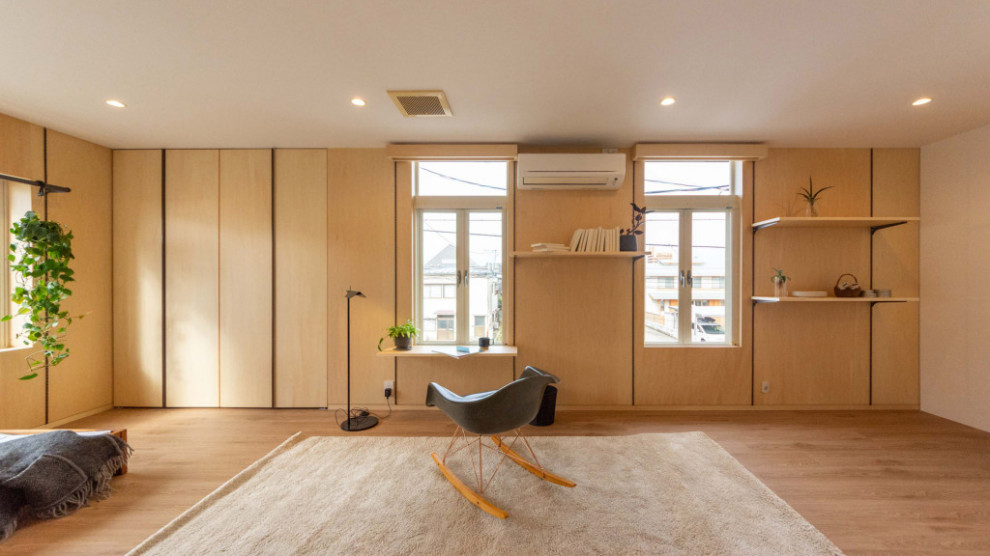 Imagen de sala de estar abierta de estilo zen con paredes beige, suelo de madera en tonos medios y televisor independiente