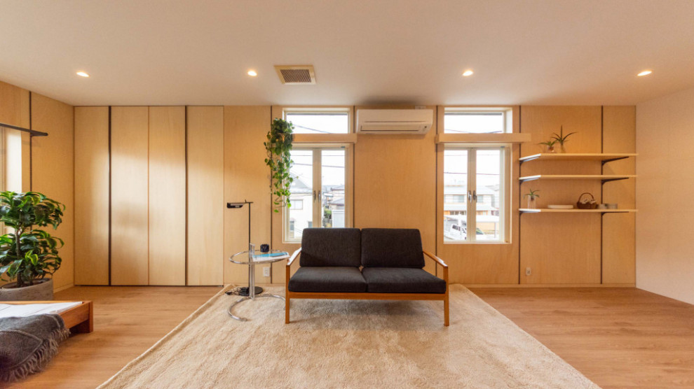 Immagine di un soggiorno etnico aperto con pareti beige, pavimento in legno massello medio e TV autoportante