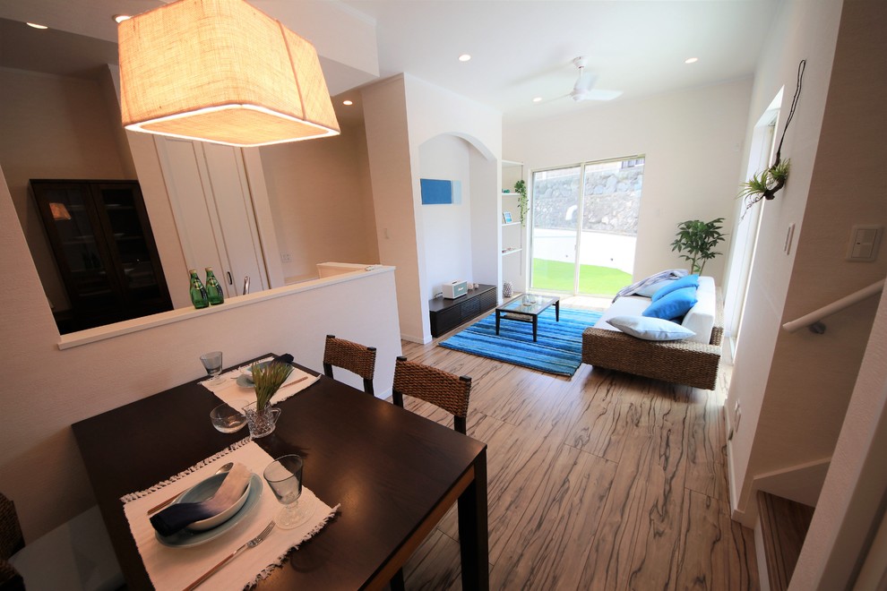 Стильный дизайн: открытая гостиная комната в восточном стиле с белыми стенами и коричневым полом - последний тренд