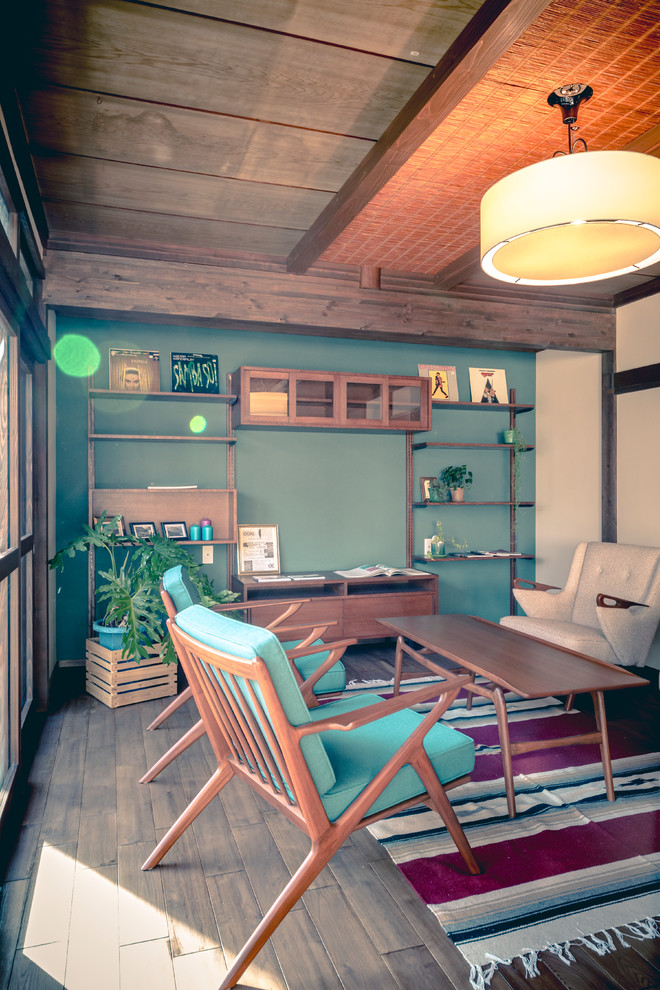 Пример оригинального дизайна: большая открытая гостиная комната в скандинавском стиле с музыкальной комнатой, зелеными стенами, темным паркетным полом, отдельно стоящим телевизором и коричневым полом без камина