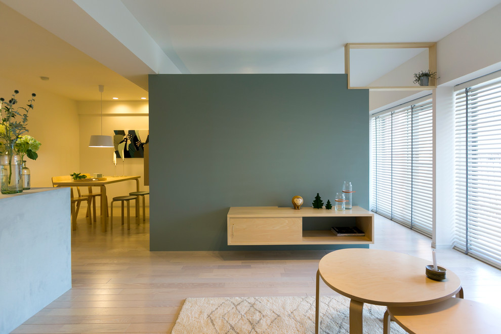На фото: гостиная комната в скандинавском стиле с синими стенами, деревянным полом и бежевым полом