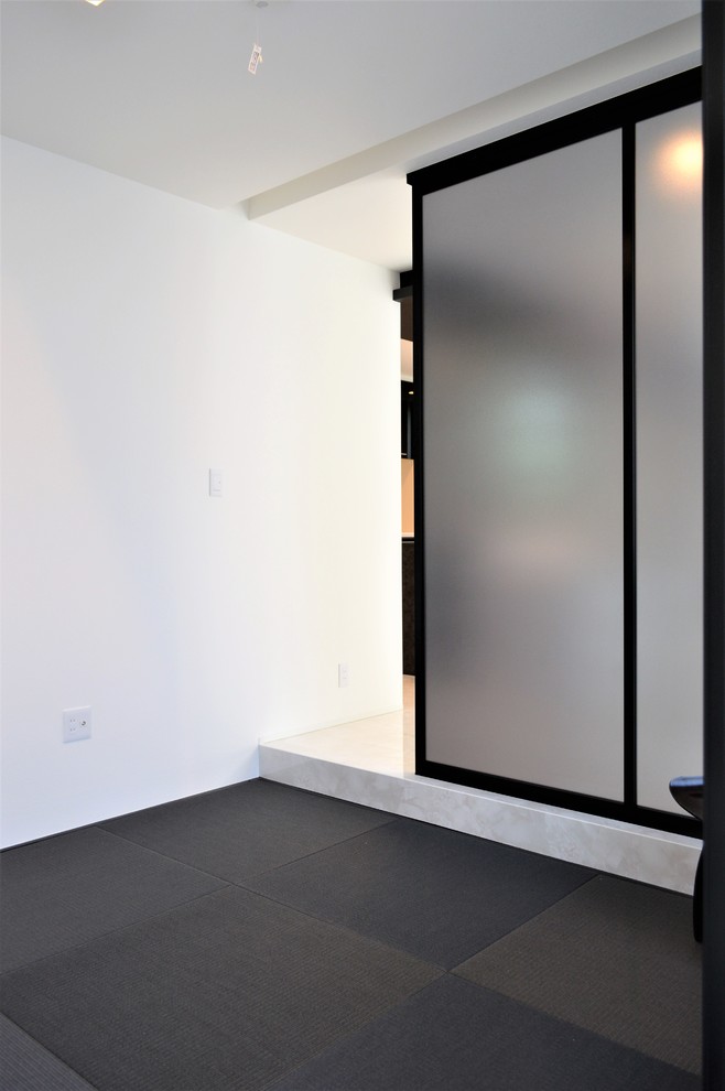 Свежая идея для дизайна: изолированная гостиная комната в стиле модернизм с белыми стенами, татами и черным полом - отличное фото интерьера