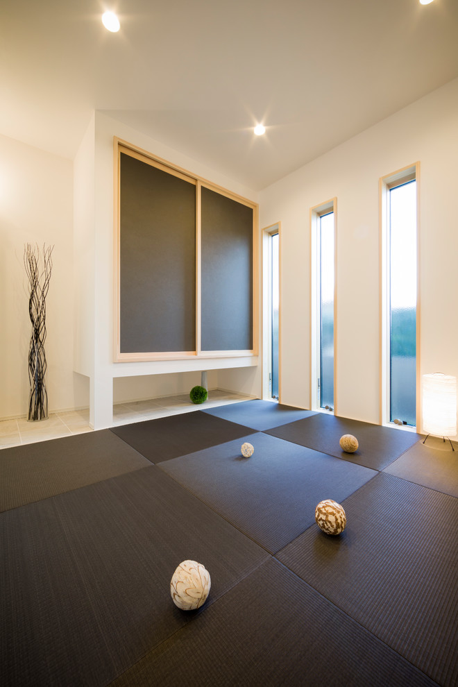 Modelo de sala de estar cerrada minimalista con paredes blancas, tatami y suelo negro