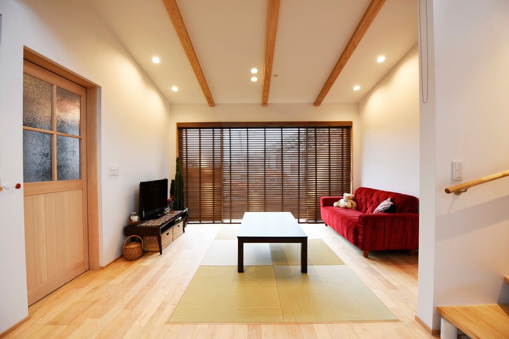 Esempio di un piccolo soggiorno etnico con pareti blu, parquet chiaro e pavimento marrone