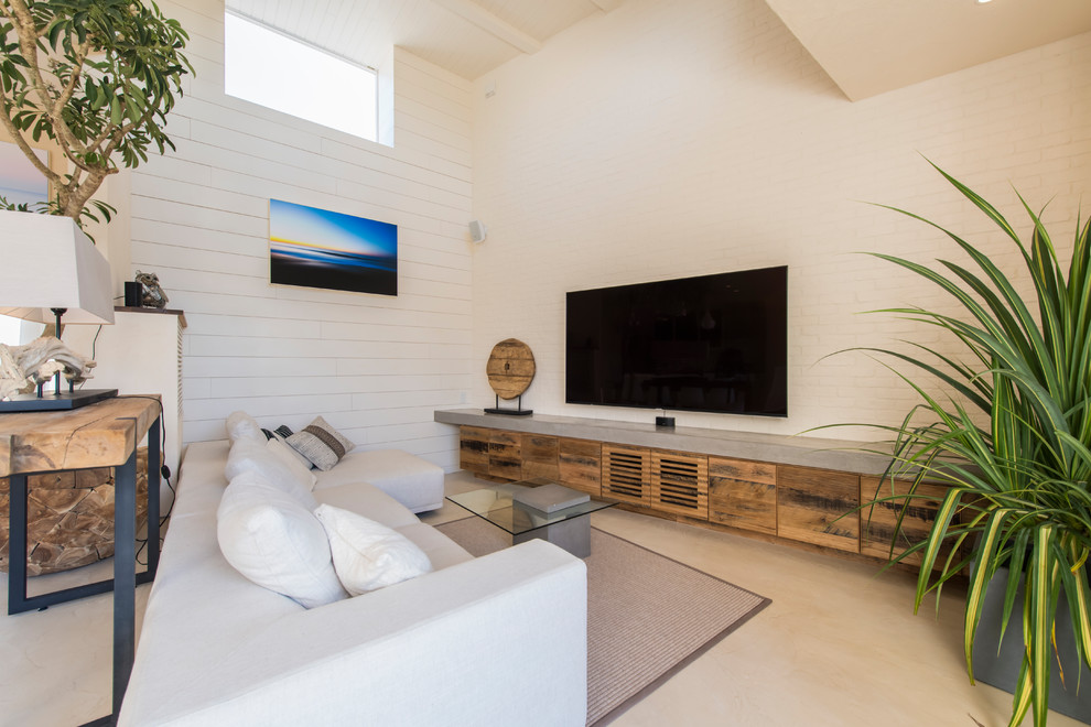 Idée de décoration pour une salle de séjour design ouverte avec un mur beige, un téléviseur fixé au mur et un sol beige.