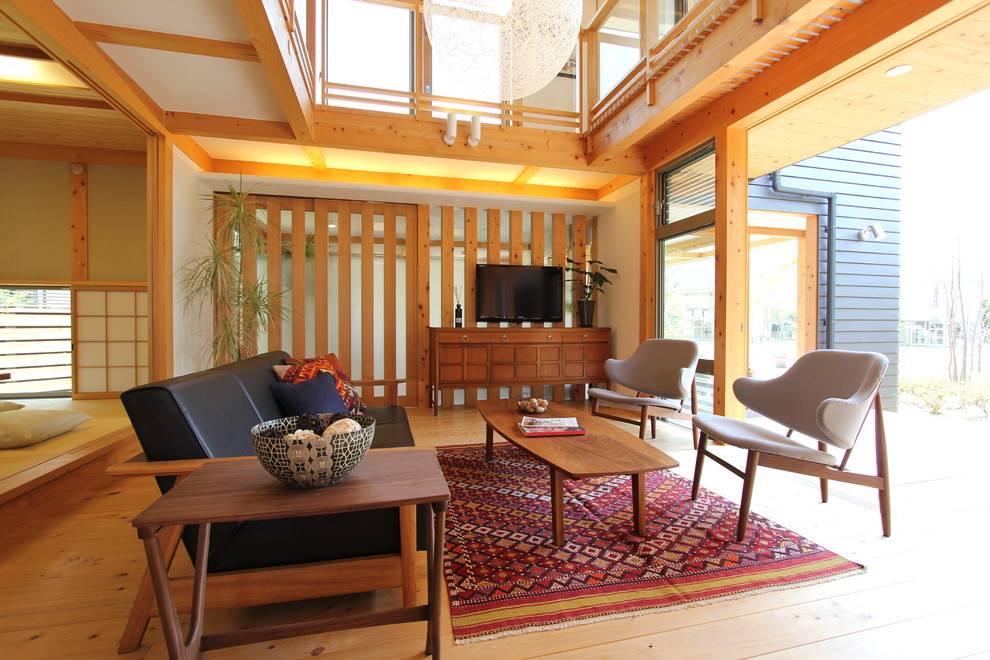 Foto de sala de estar de estilo zen con paredes blancas, suelo de madera en tonos medios, televisor colgado en la pared y suelo marrón