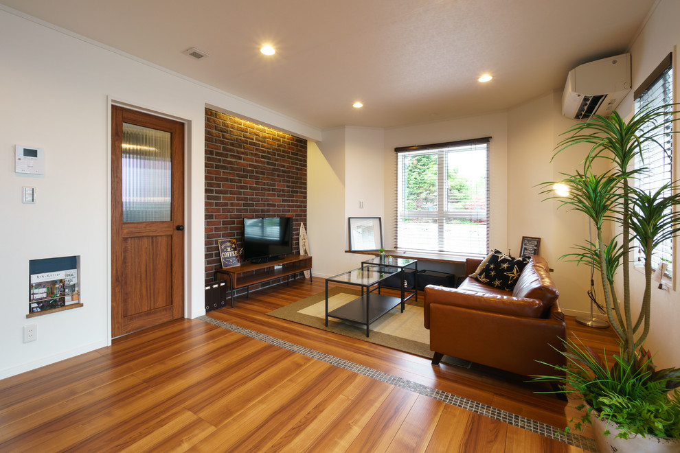 Ispirazione per un soggiorno stile marinaro aperto con pareti bianche, pavimento in legno massello medio, TV autoportante e pavimento marrone
