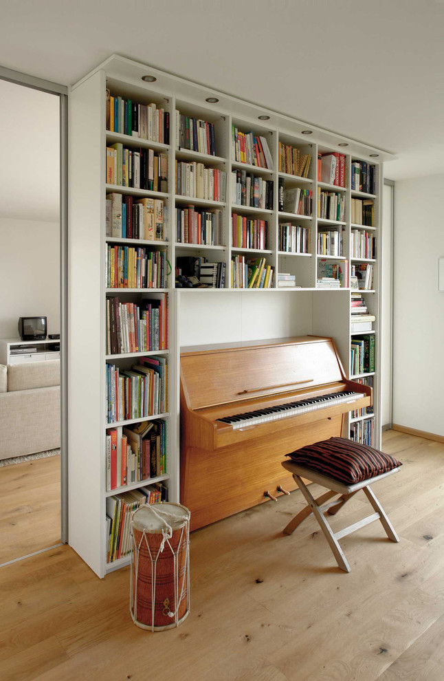 Foto de sala de estar minimalista sin chimenea con paredes blancas y suelo de madera clara
