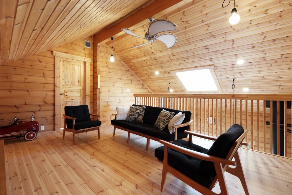 Photo of a world-inspired games room with brown walls, medium hardwood flooring and brown floors.