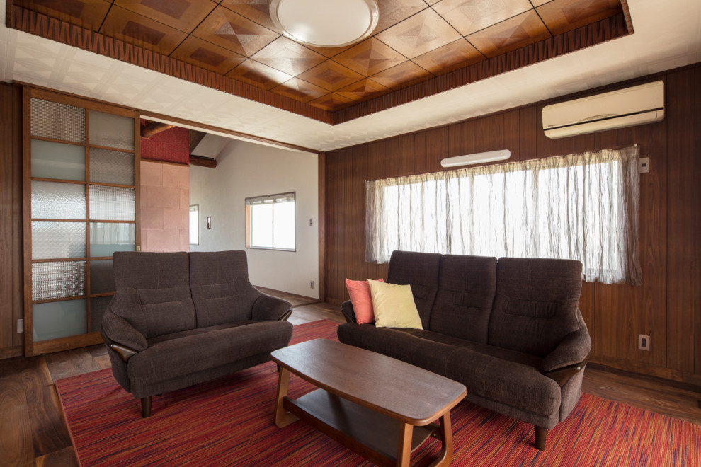 Immagine di un soggiorno chiuso con pareti marroni, parquet scuro, TV autoportante, pavimento marrone, soffitto ribassato e pareti in legno