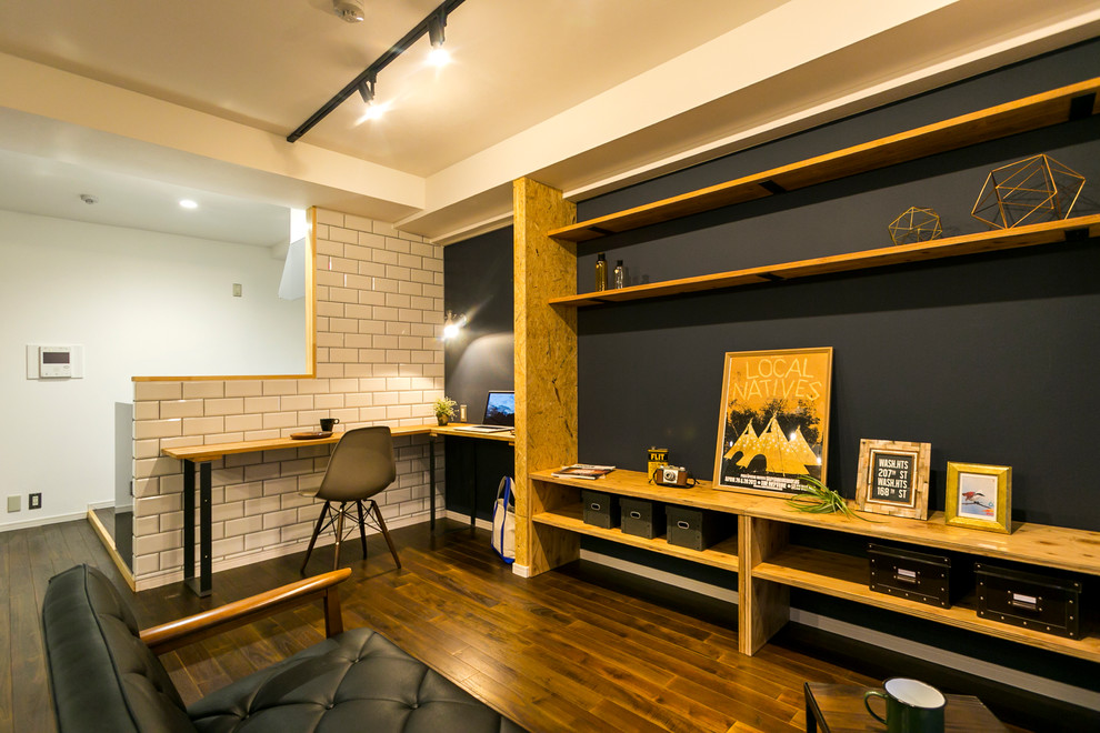 Industrial Wohnzimmer mit schwarzer Wandfarbe, dunklem Holzboden und braunem Boden in Sonstige