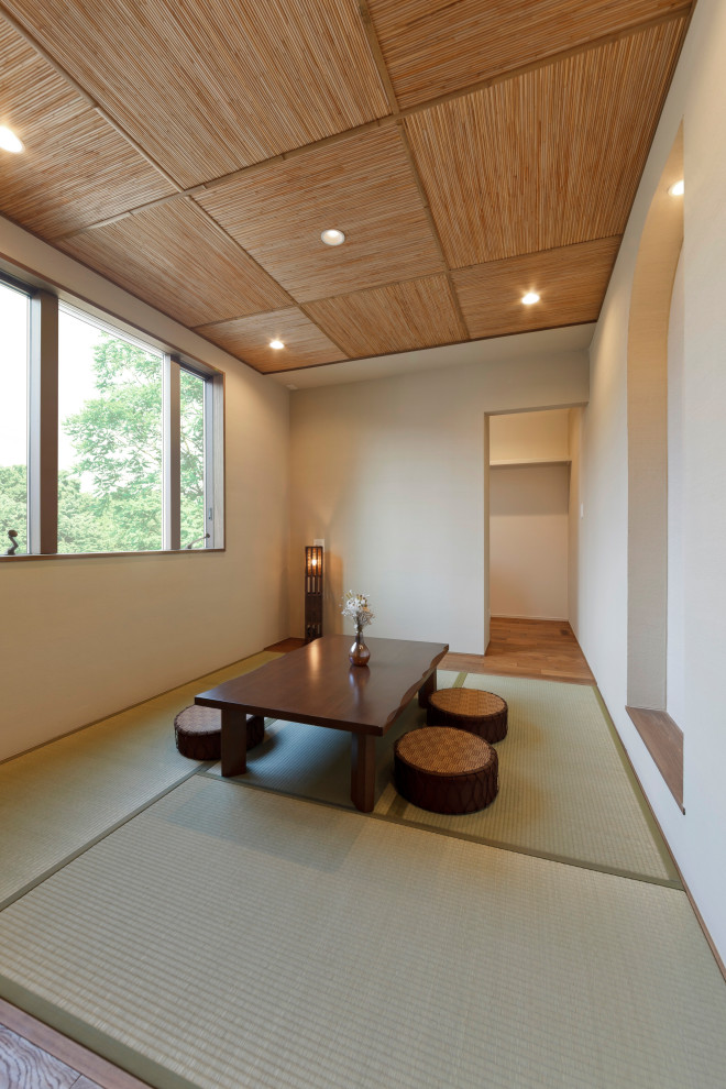 Стильный дизайн: изолированная гостиная комната с бежевыми стенами, татами, зеленым полом, кессонным потолком и стенами из вагонки - последний тренд