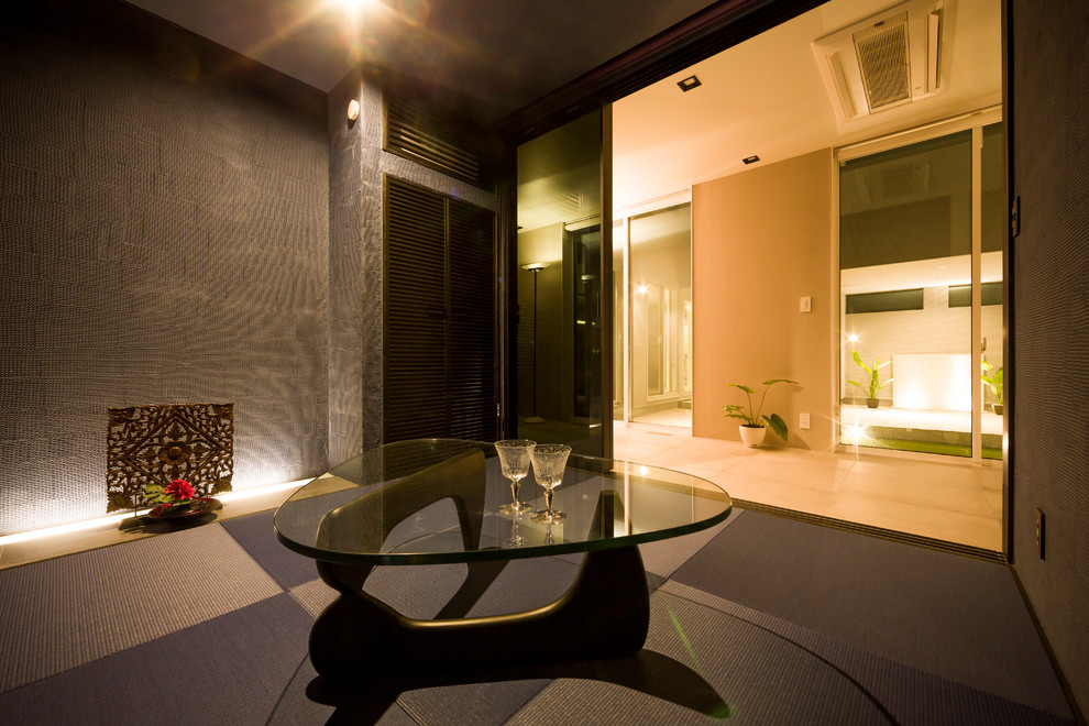 Immagine di un soggiorno etnico con pareti nere, pavimento in tatami e pavimento nero