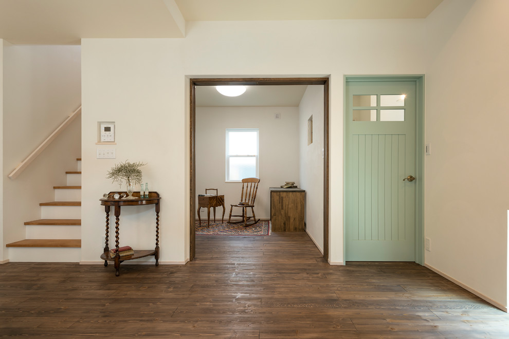 Diseño de sala de estar de estilo de casa de campo con paredes blancas, suelo de madera en tonos medios y suelo marrón