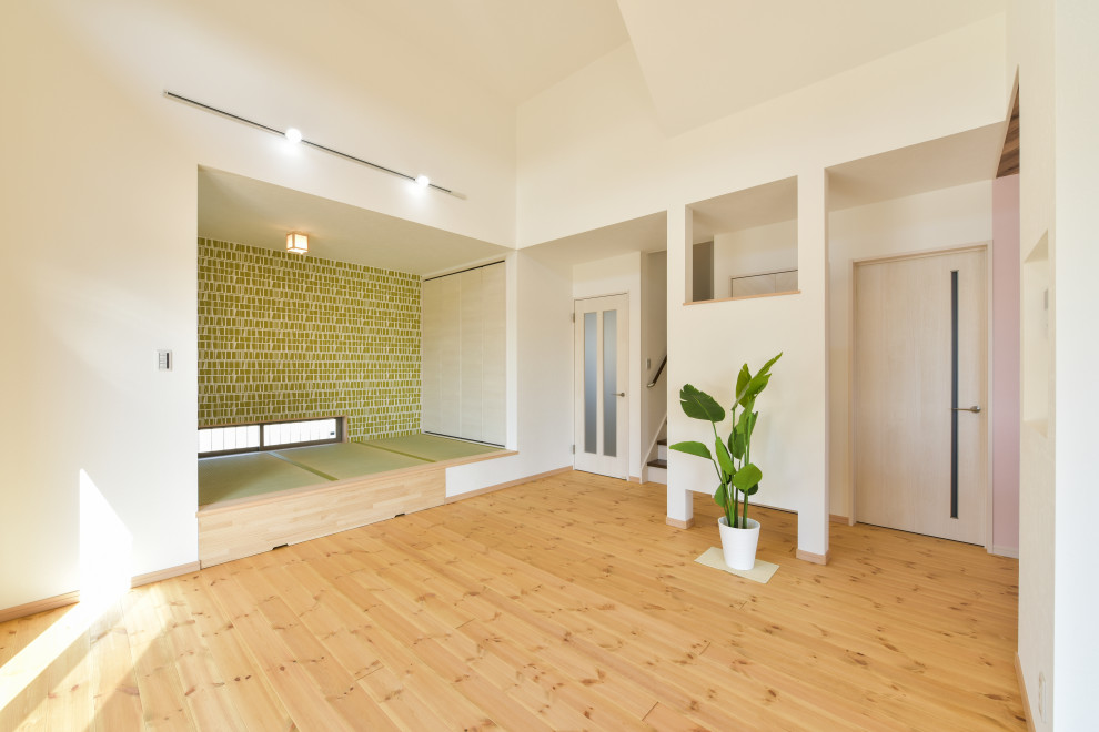Maritim inredning av ett mellanstort allrum med öppen planlösning, med beige väggar, tatamigolv och grönt golv