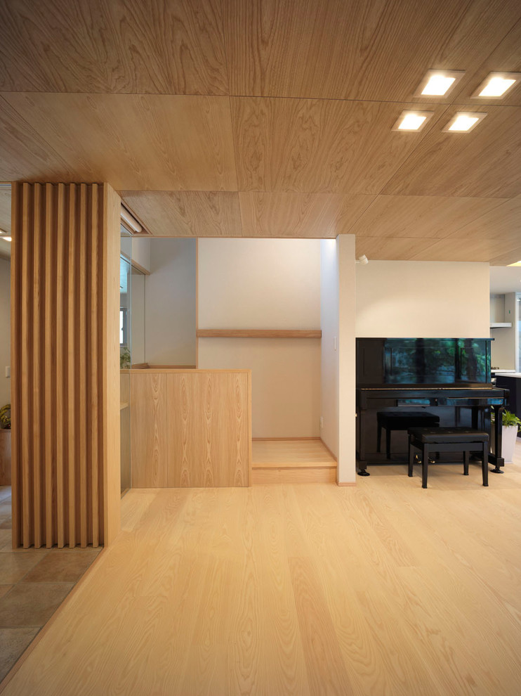 Mittelgroßes, Offenes Modernes Wohnzimmer mit beiger Wandfarbe, hellem Holzboden, freistehendem TV und beigem Boden in Sonstige