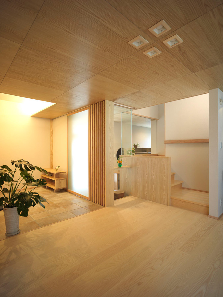 Modern inredning av ett mellanstort allrum med öppen planlösning, med beige väggar, ljust trägolv, en fristående TV och beiget golv