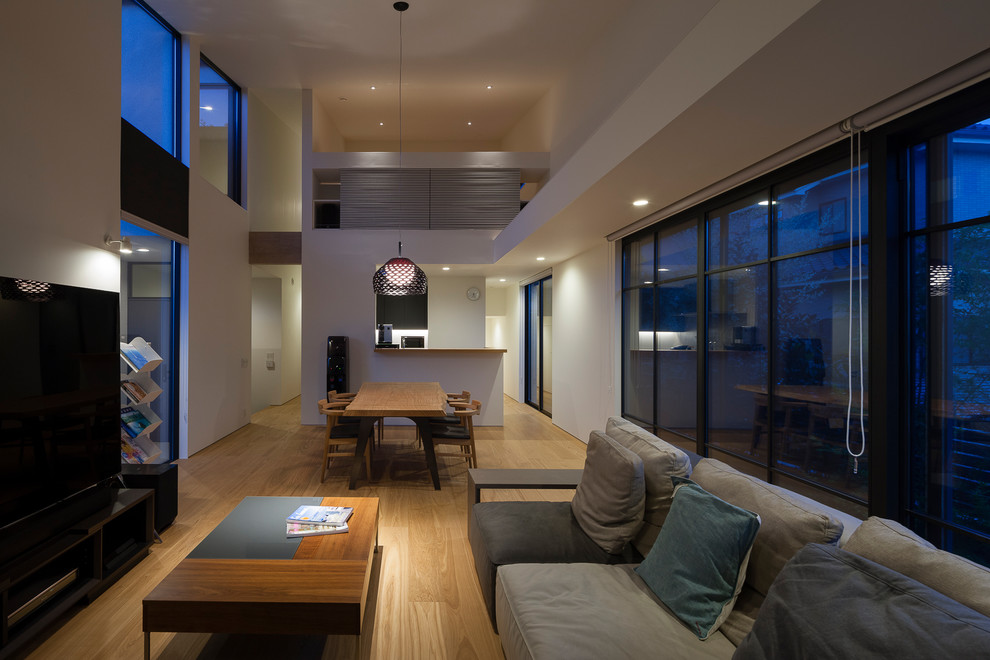 Idée de décoration pour une salle de séjour design ouverte avec un mur blanc, un sol en bois brun, un téléviseur indépendant et un sol marron.