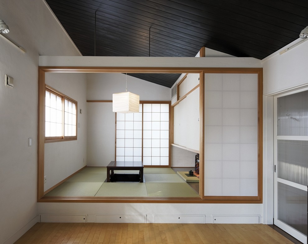 Asiatisches Esszimmer mit weißer Wandfarbe, Tatami-Boden und grünem Boden in Osaka