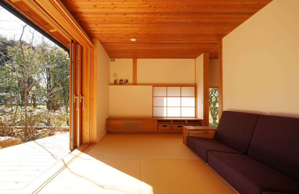 Cette image montre une salle de séjour asiatique avec un mur beige, un sol de tatami et un sol vert.