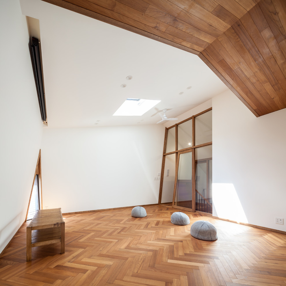 Aménagement d'une salle de séjour asiatique avec un mur blanc et un sol en bois brun.