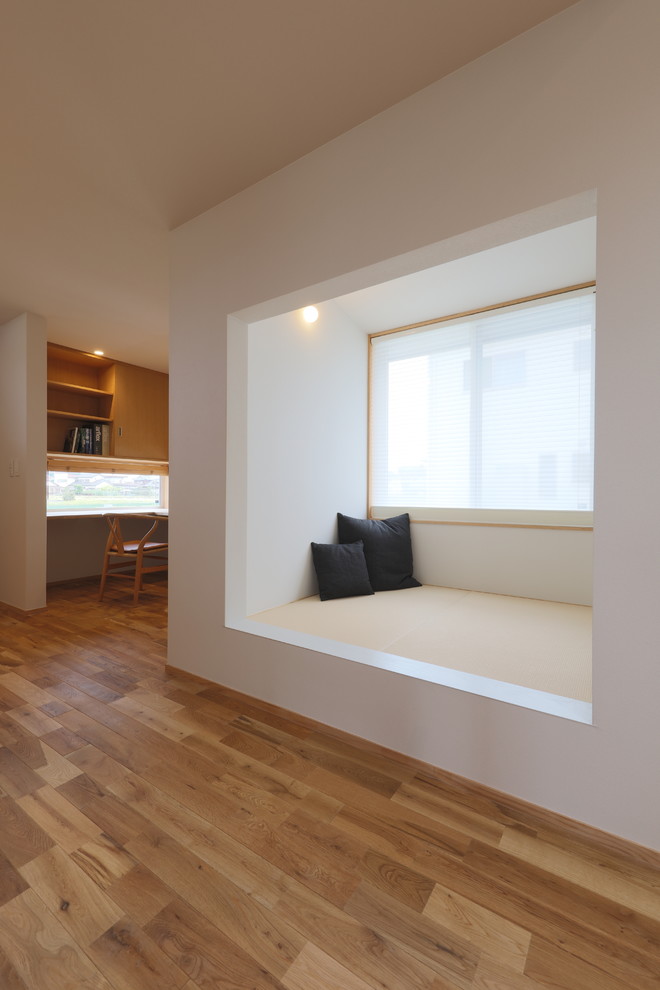 Imagen de sala de estar blanca moderna con paredes blancas, tatami, suelo marrón, papel pintado y papel pintado