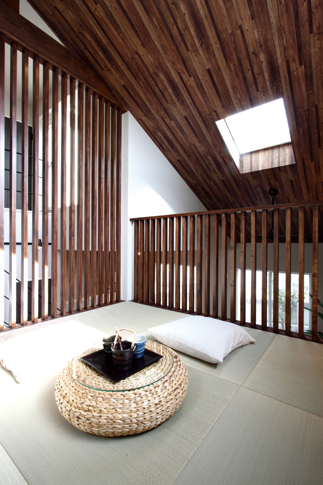 Cette photo montre une salle de séjour asiatique avec un mur blanc, un sol de tatami et un sol vert.