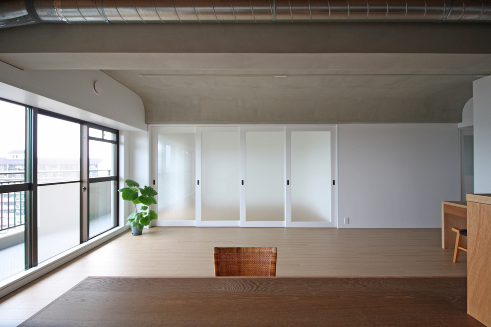 Пример оригинального дизайна: открытая гостиная комната в стиле ретро с белыми стенами, полом из фанеры и коричневым полом