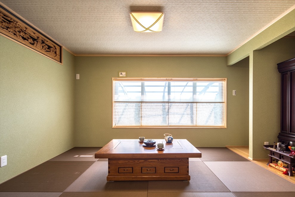 Cette image montre une salle de séjour asiatique avec un mur vert et aucune cheminée.