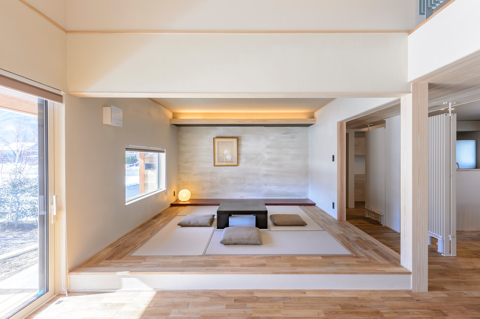 Inredning av ett allrum, med flerfärgade väggar, tatamigolv och grått golv