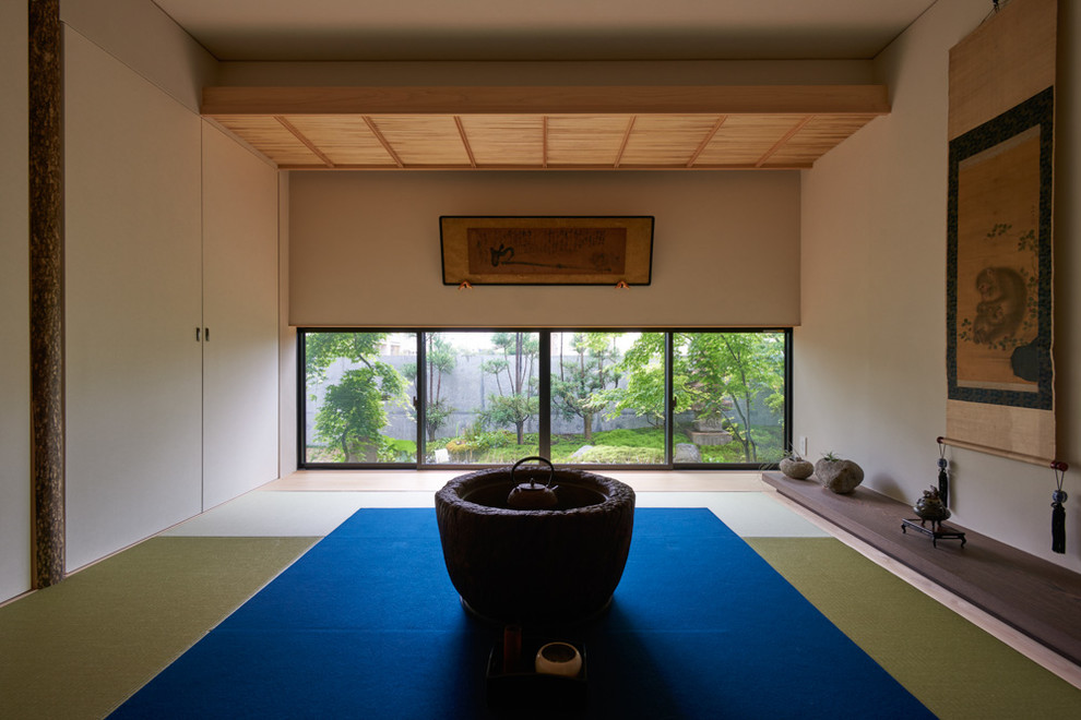 Exemple d'une salle de séjour asiatique avec un mur beige et un sol de tatami.