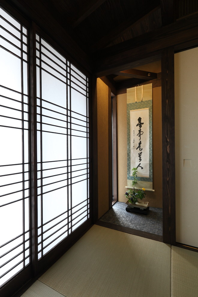Asiatisk inredning av ett mellanstort avskilt allrum, med ett bibliotek, beige väggar, tatamigolv och grönt golv