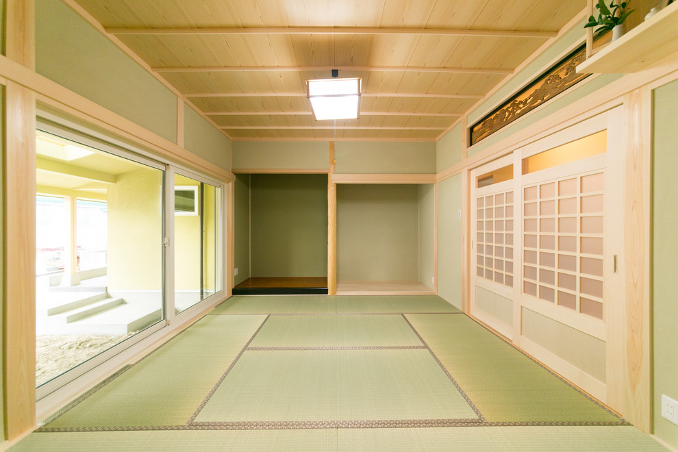 Cette image montre une salle de séjour asiatique avec un mur vert, un sol de tatami, aucune cheminée et aucun téléviseur.