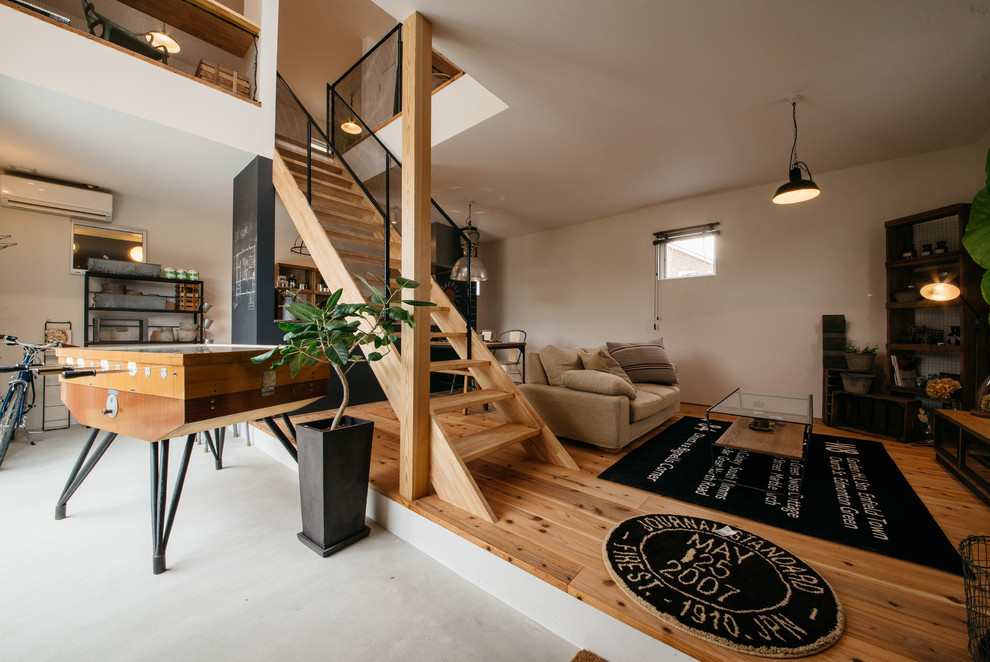 Ispirazione per un soggiorno industriale aperto con pareti bianche, pavimento in legno massello medio e pavimento marrone