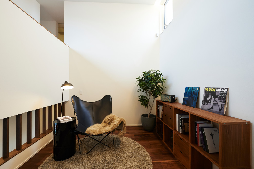 Immagine di un soggiorno minimalista di medie dimensioni e stile loft con libreria, pareti bianche, parquet scuro, nessun camino, nessuna TV, pavimento marrone, soffitto in carta da parati e carta da parati