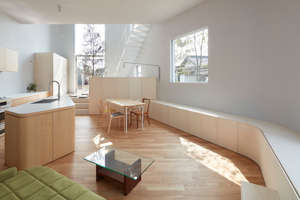 Idée de décoration pour une salle de séjour nordique ouverte avec un mur gris, parquet clair et un sol marron.