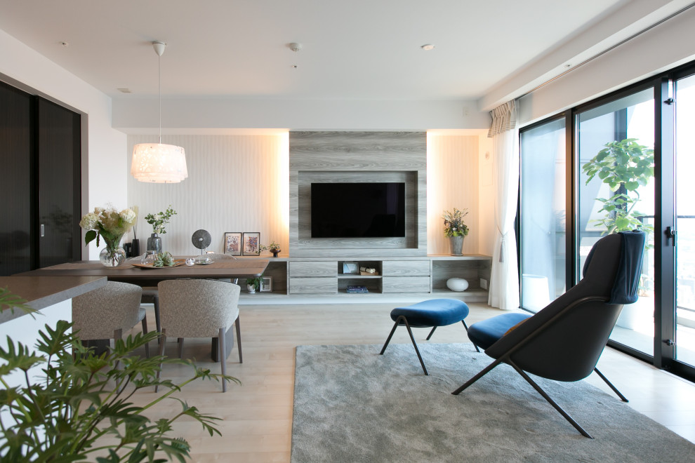 Imagen de sala de estar abierta minimalista sin chimenea con paredes blancas, suelo de contrachapado, televisor colgado en la pared, papel pintado y papel pintado