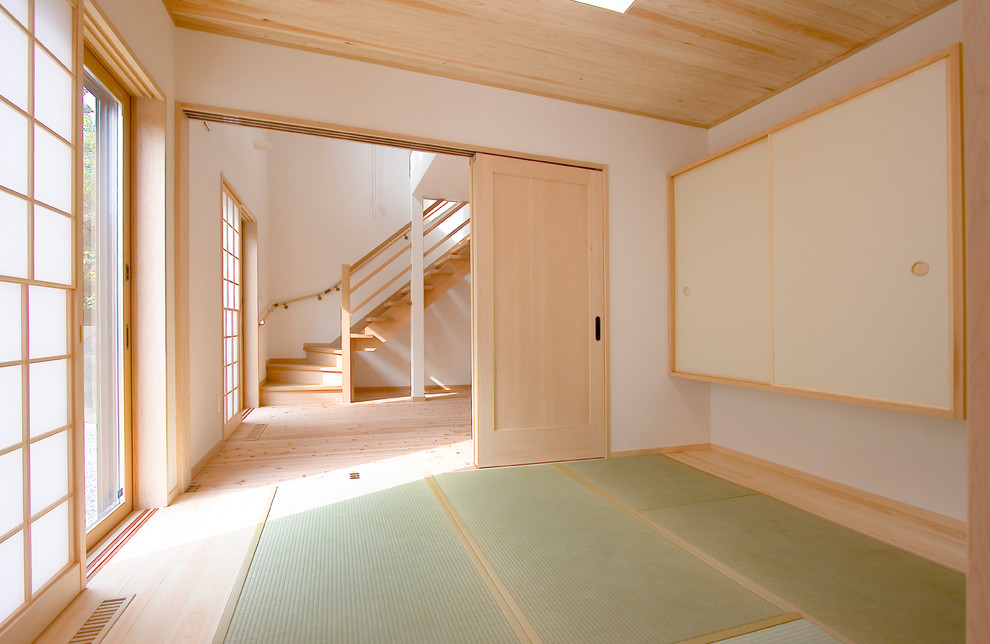 Réalisation d'une salle de séjour asiatique fermée avec un mur blanc, un sol de tatami et un sol vert.