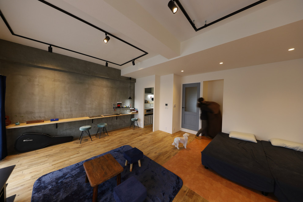 Idée de décoration pour une salle de séjour nordique avec un mur gris et un sol en bois brun.