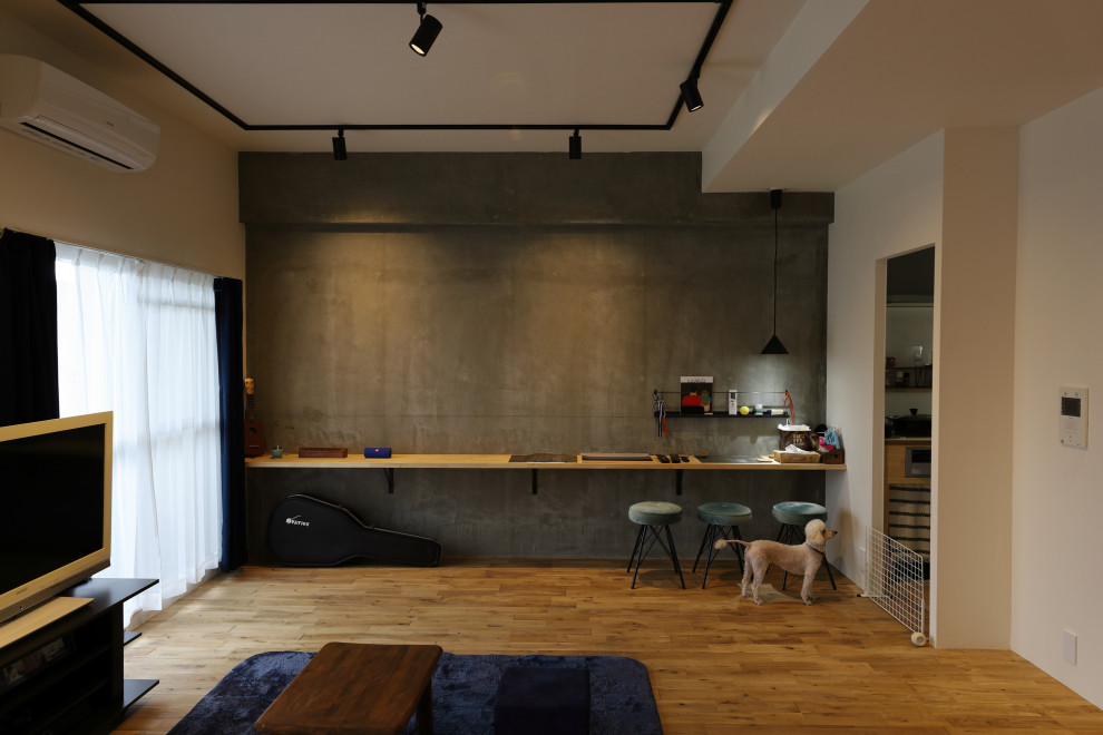 Aménagement d'une salle de séjour scandinave avec un mur gris et un sol en bois brun.