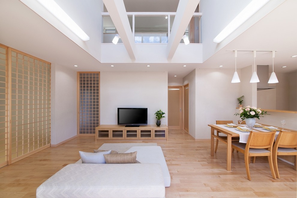 Imagen de sala de estar asiática con paredes blancas, suelo de madera clara y suelo marrón