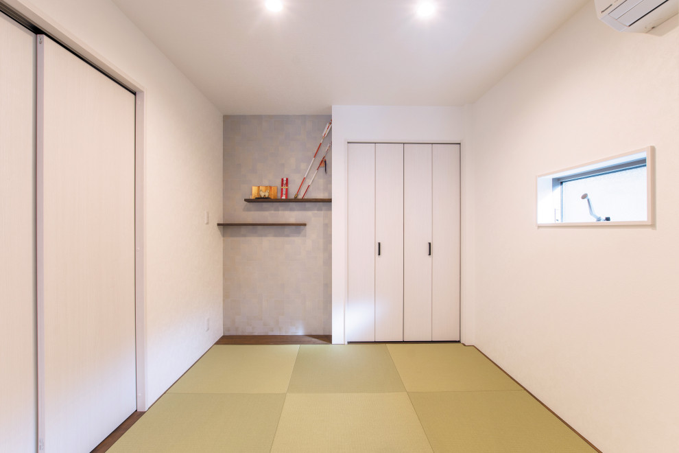 Immagine di un piccolo soggiorno etnico aperto con sala giochi, pareti bianche, pavimento in tatami, nessun camino e pavimento verde