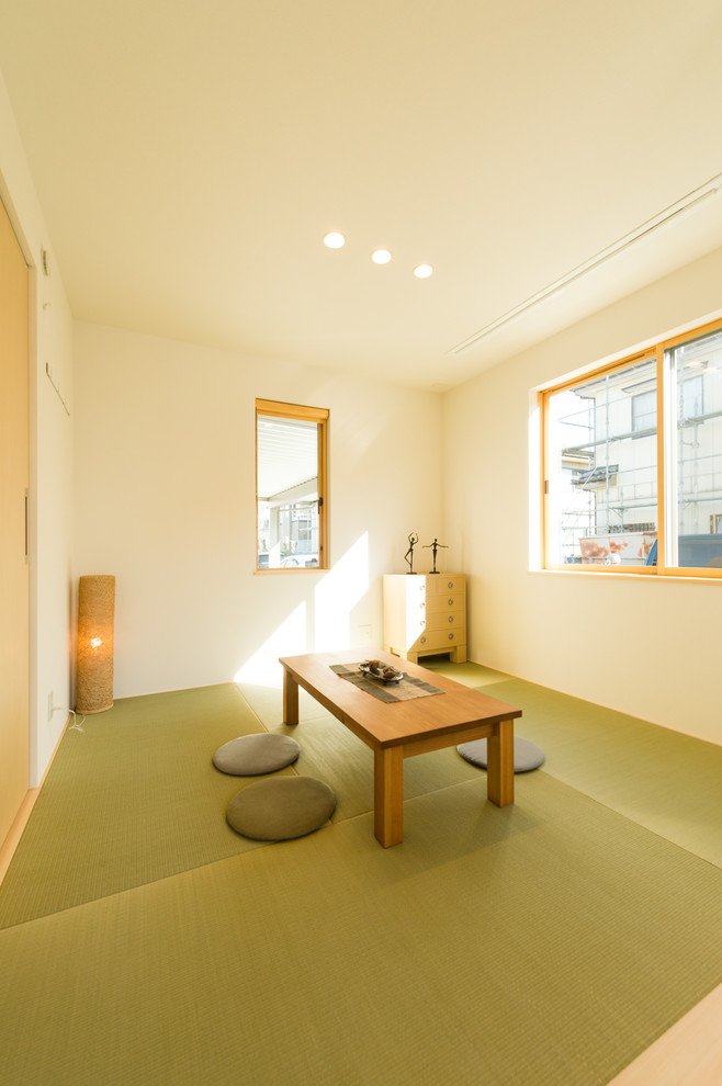 This is an example of a world-inspired games room in Other with white walls, tatami flooring and green floors.