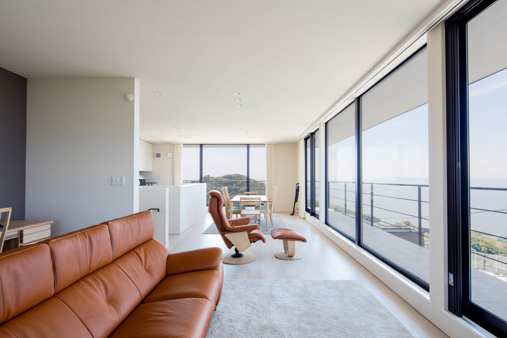 Идея дизайна: гостиная комната в стиле модернизм с белыми стенами, деревянным полом и бежевым полом