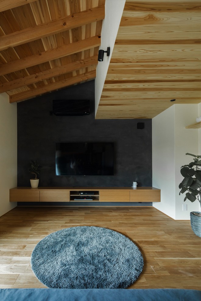 Idéer för mellanstora orientaliska allrum med öppen planlösning, med beige väggar, mellanmörkt trägolv, en väggmonterad TV och beiget golv