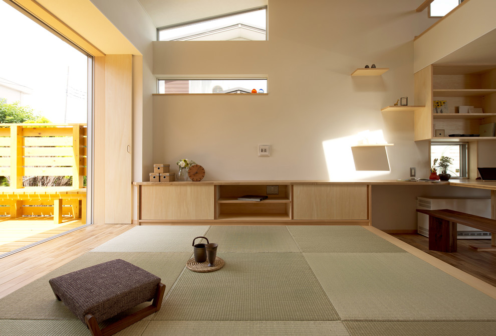 Пример оригинального дизайна: открытая гостиная комната в восточном стиле с белыми стенами, татами и зеленым полом