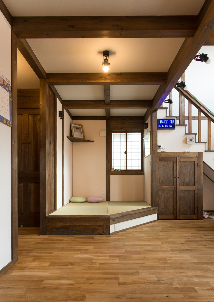 Ejemplo de sala de estar asiática con paredes blancas, suelo de madera en tonos medios y suelo marrón
