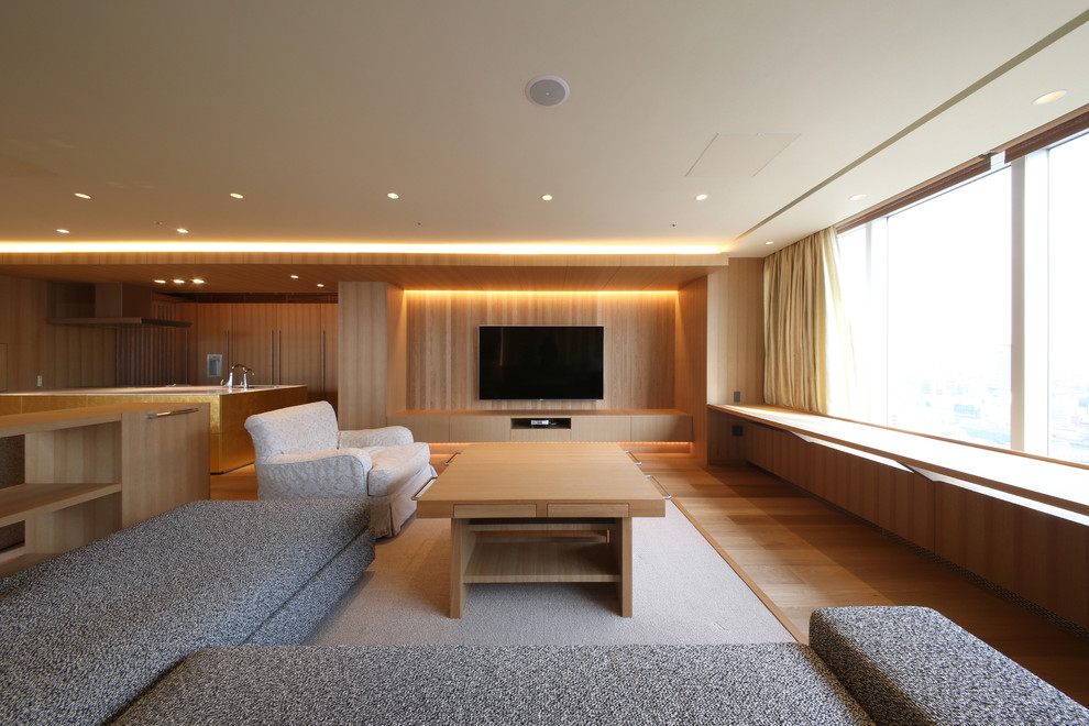 Foto de sala de estar abierta minimalista sin chimenea con paredes marrones, suelo de madera en tonos medios, televisor colgado en la pared y suelo marrón